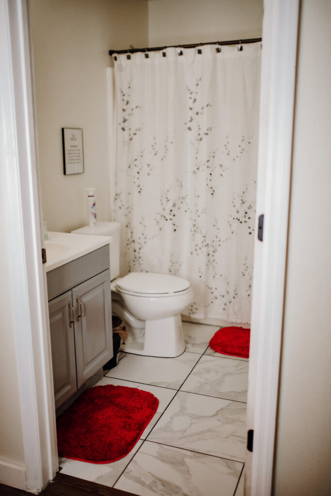 Clean and inviting bathroom with red mats in the Fresh Life Recovery Homes in Bradenton, Florida.